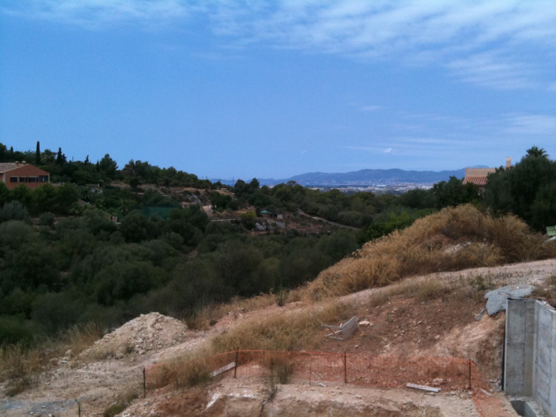View from the balcony with the excavated pool below and looking over the valley of pine trees with the bay of Palma and Tramuntana mountains on the horizon